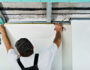 Le travailleur mesure le cadre avant d'installer la cloison sèche. pose d'un faux plafond en plaques de plâtre